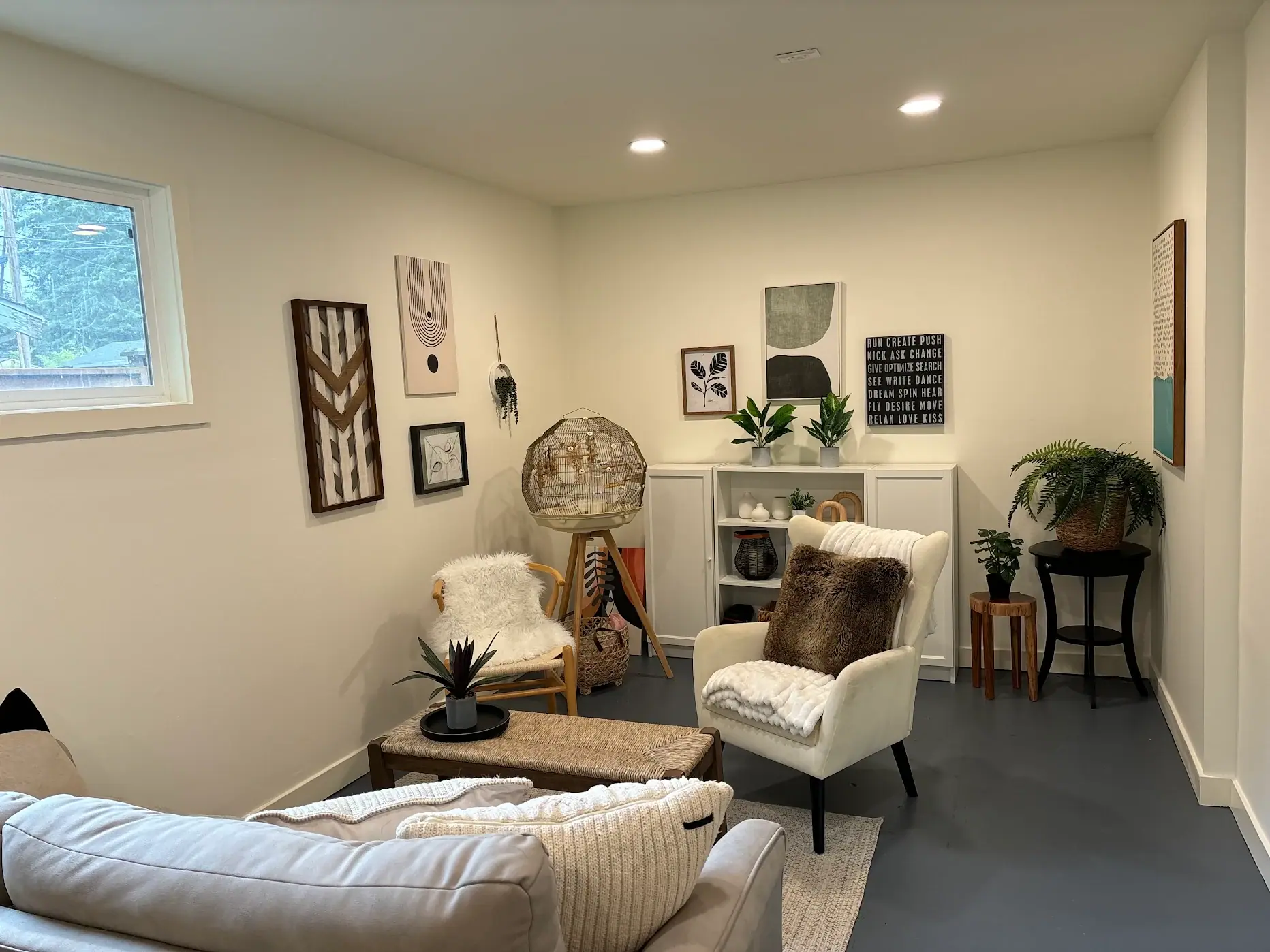 Bright sitting room with white walls, recessed lighting and a painted floor