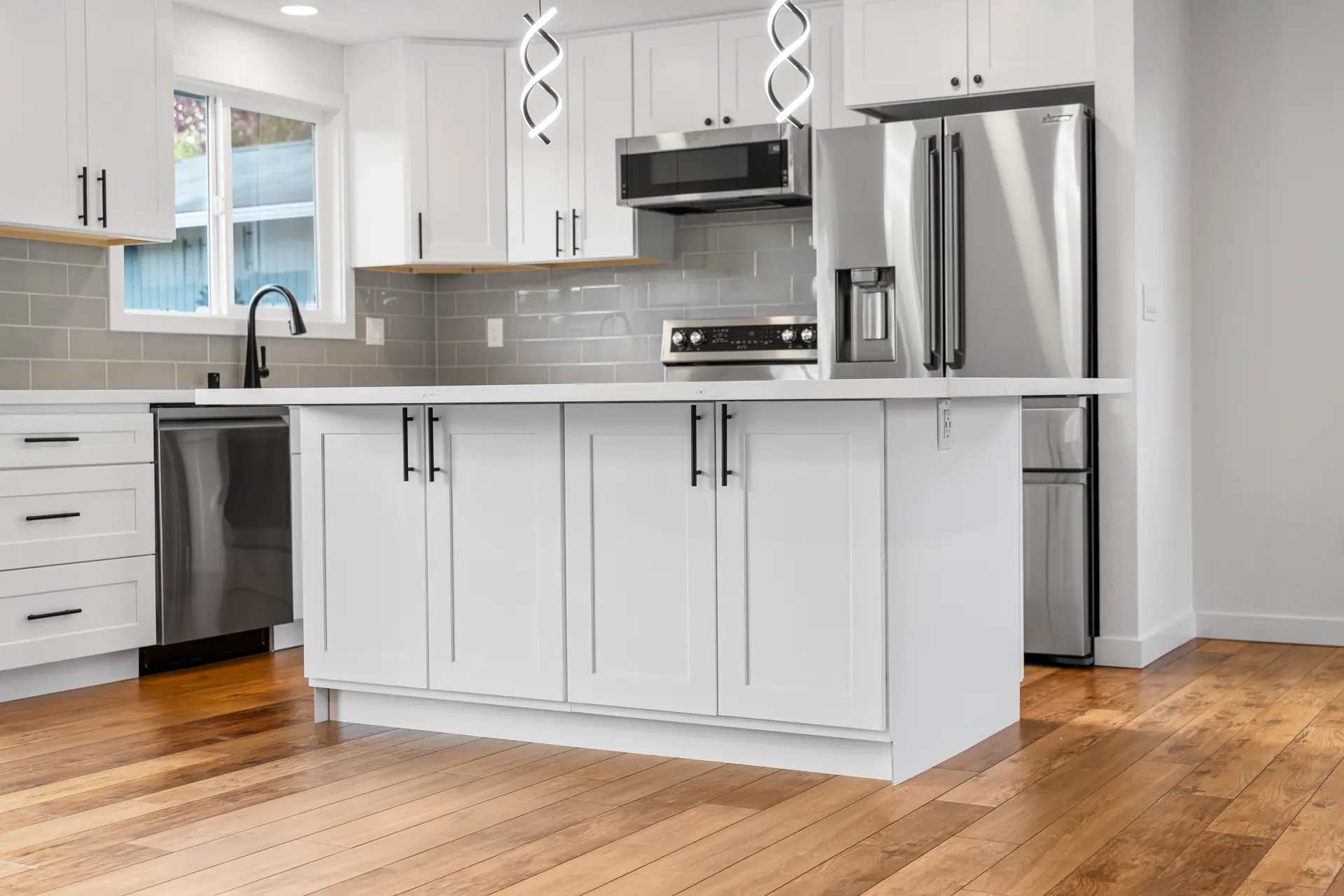 White shaker kitchen island with black hardware and white countertop