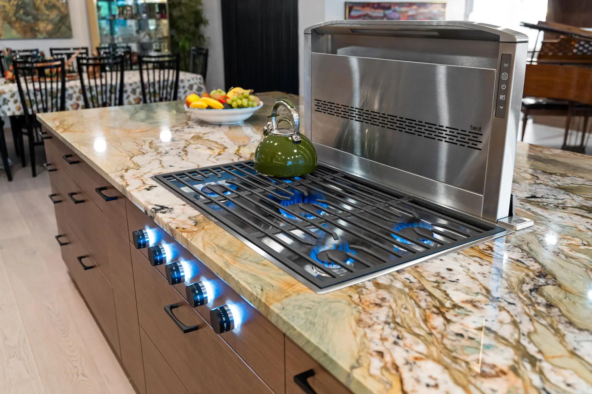 Gas cooktop with a pop-up vent set into a boldly veined countertop